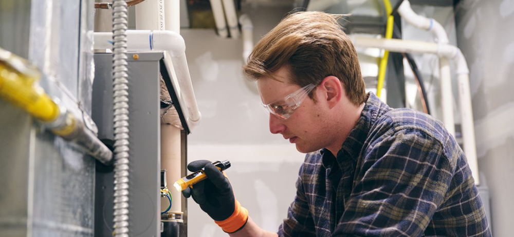 Elwood Heating Inc. technician reviewing furnace repair options with a homeowner in Elwood, NY